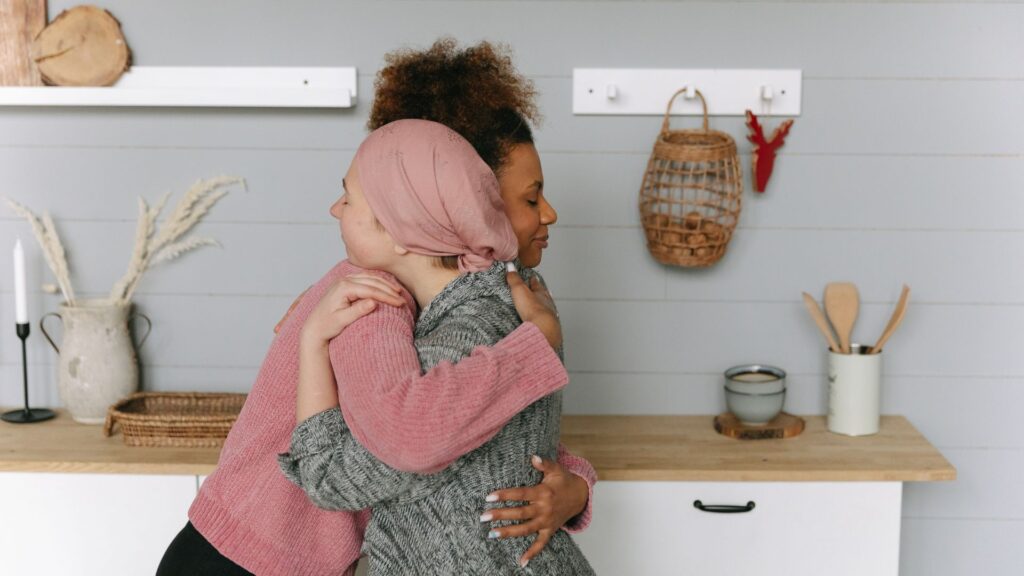 Imagen que muestra el acompañamiento emocional que brindan los familiares a una persona diagnosticada con cáncer, destacando la importancia del soporte humano en el proceso de recuperación.